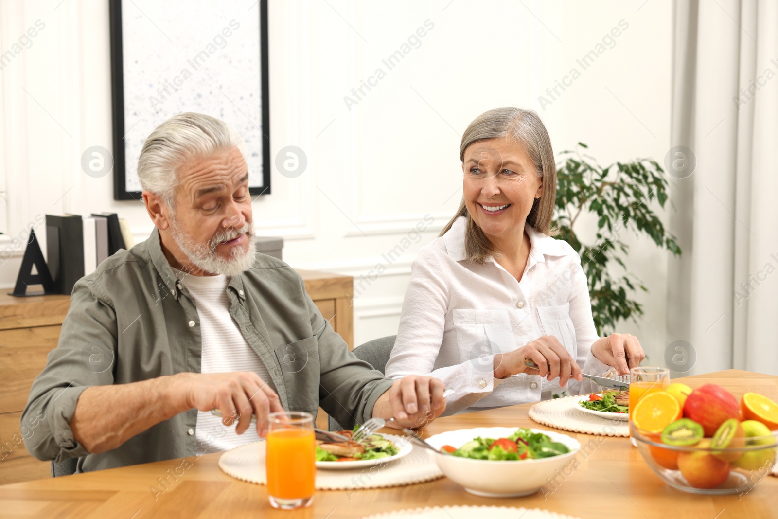 Photo of Happy senior couple having dinner at home