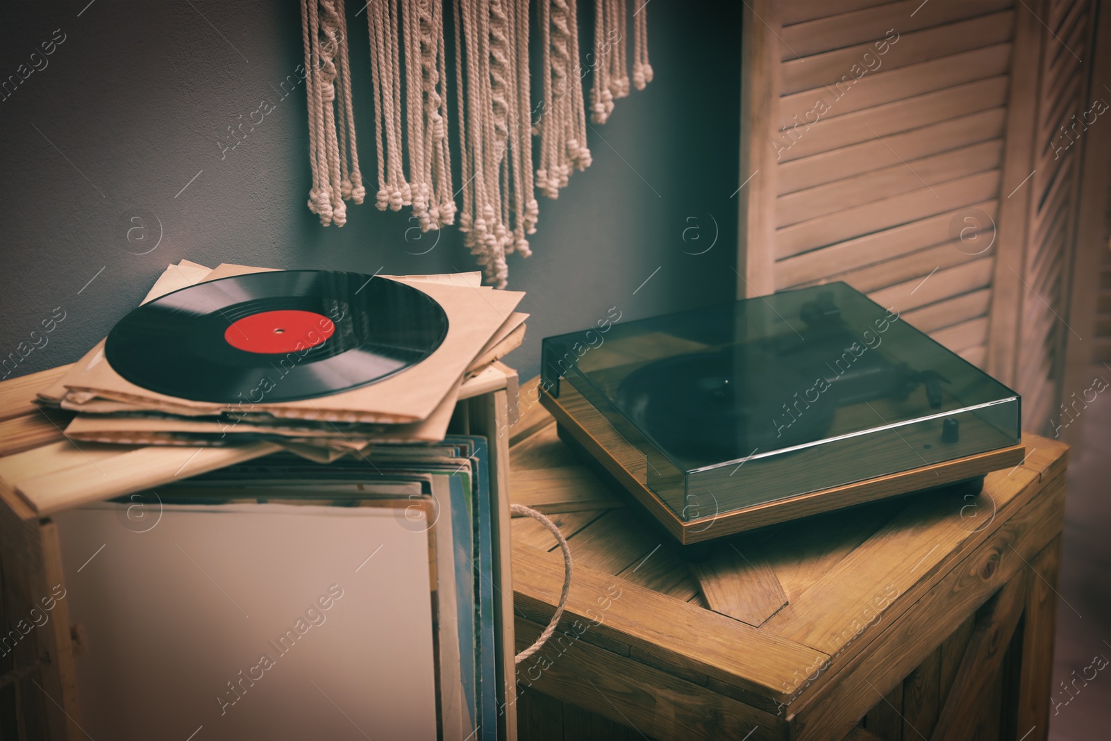 Image of Stylish turntable on wooden crate in room