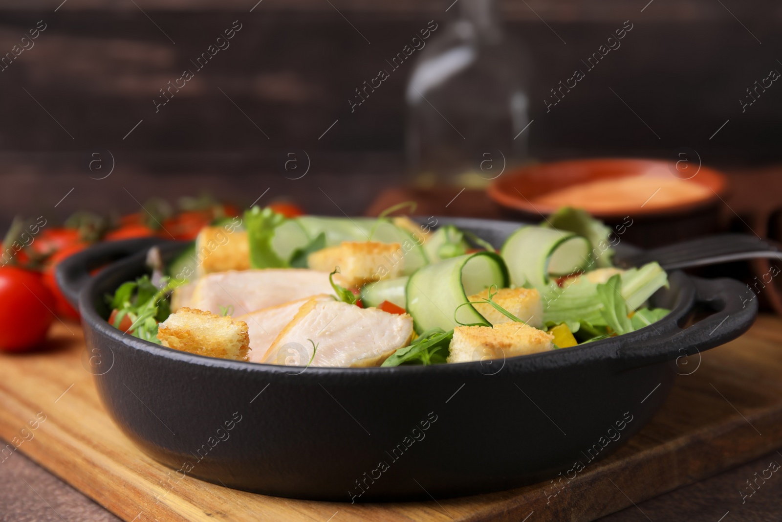 Photo of Delicious salad with croutons, chicken and vegetables served on grey table, closeup