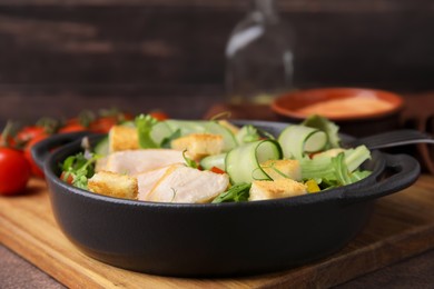 Delicious salad with croutons, chicken and vegetables served on grey table, closeup