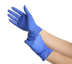 Woman putting on blue latex gloves against white background, closeup of hands