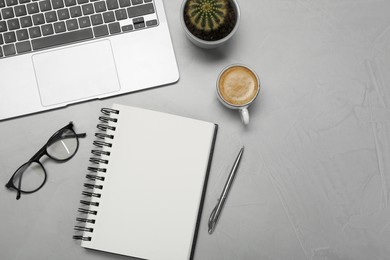 Photo of Flat lay composition with open notebook and laptop on light grey table