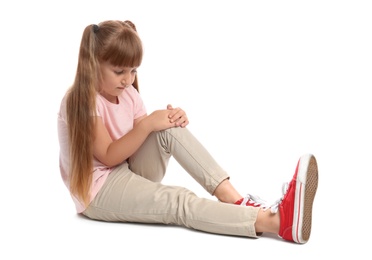Photo of Full length portrait of little girl with knee problems sitting on white background