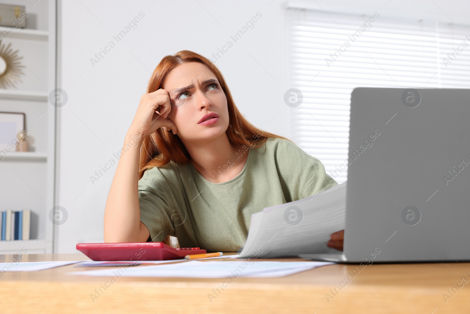 Photo of Woman doing taxes at table in room