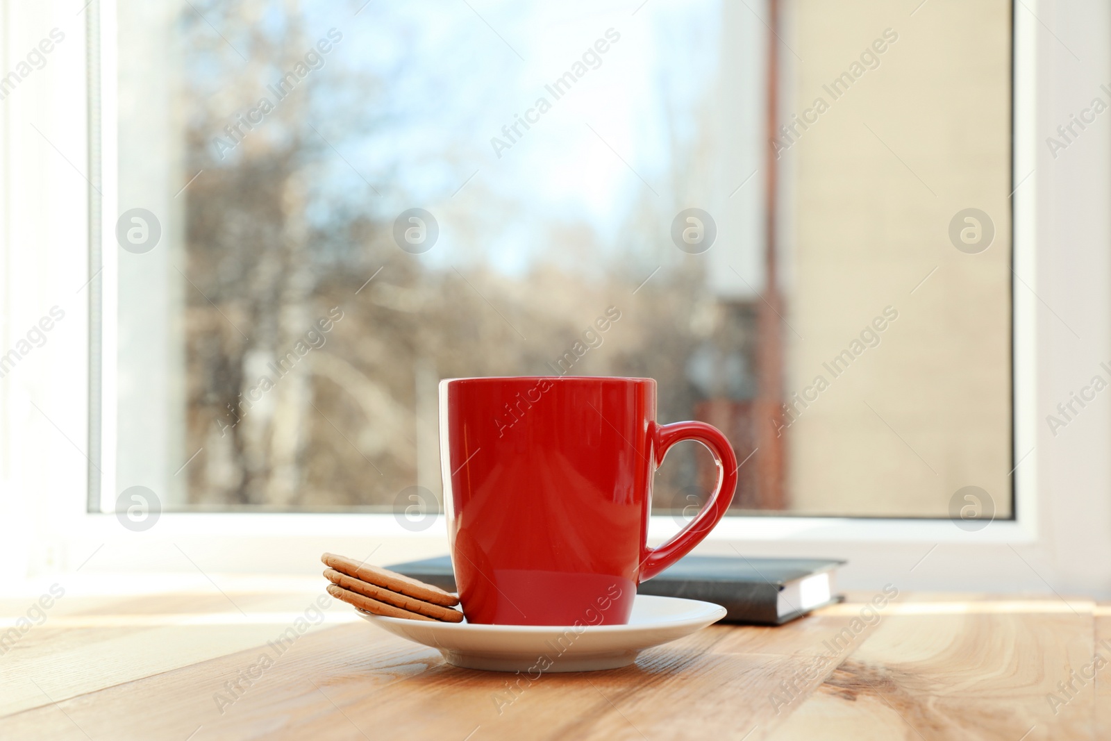 Photo of Cup of hot winter drink and cookies on wooden windowsill, space for text