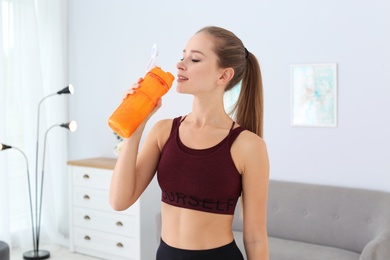 Photo of Woman drinking protein shake in living room