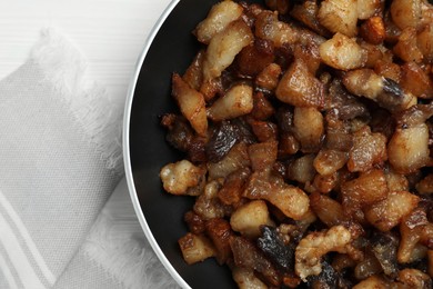 Photo of Tasty fried cracklings on white table, top view. Cooked pork lard