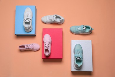 Photo of Flat lay composition with different stylish sports shoes on pale coral background