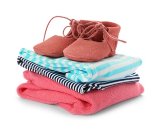 Photo of Stack of child clothes and cute shoes isolated on white