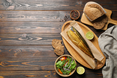 Photo of Flat lay composition with tasty smoked fish on wooden table. Space for text