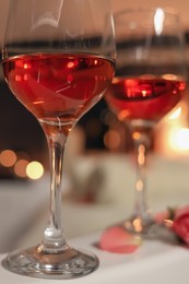 Photo of Wine in glasses on edge of bath indoors, closeup. Romantic atmosphere