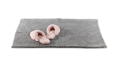 Photo of New grey bath mat with fluffy slippers isolated on white