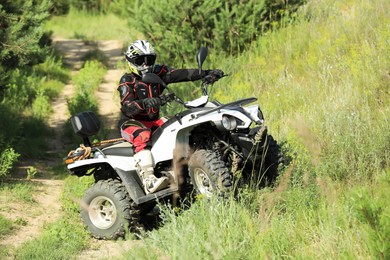 Photo of Man performing trick with modern quad bike outdoors. Extreme sport