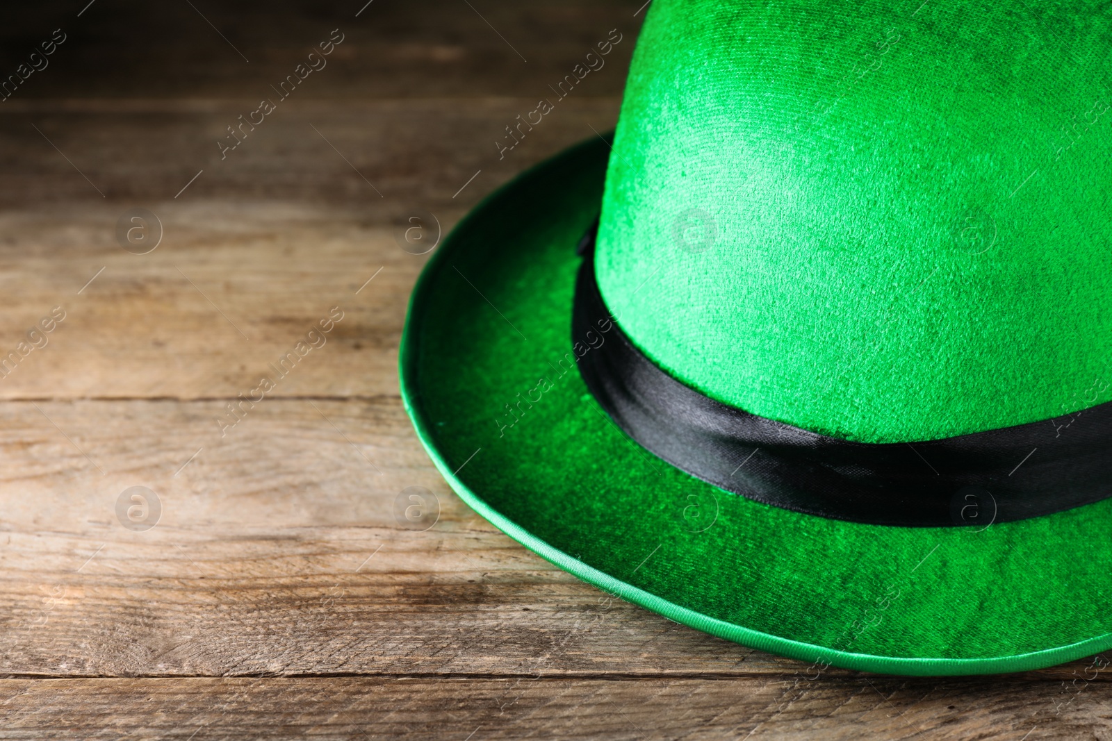 Photo of Green leprechaun hat on wooden table, closeup. St. Patrick's Day celebration