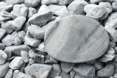 Photo of Presentation for product. Stone podium on grey pebbles, top view