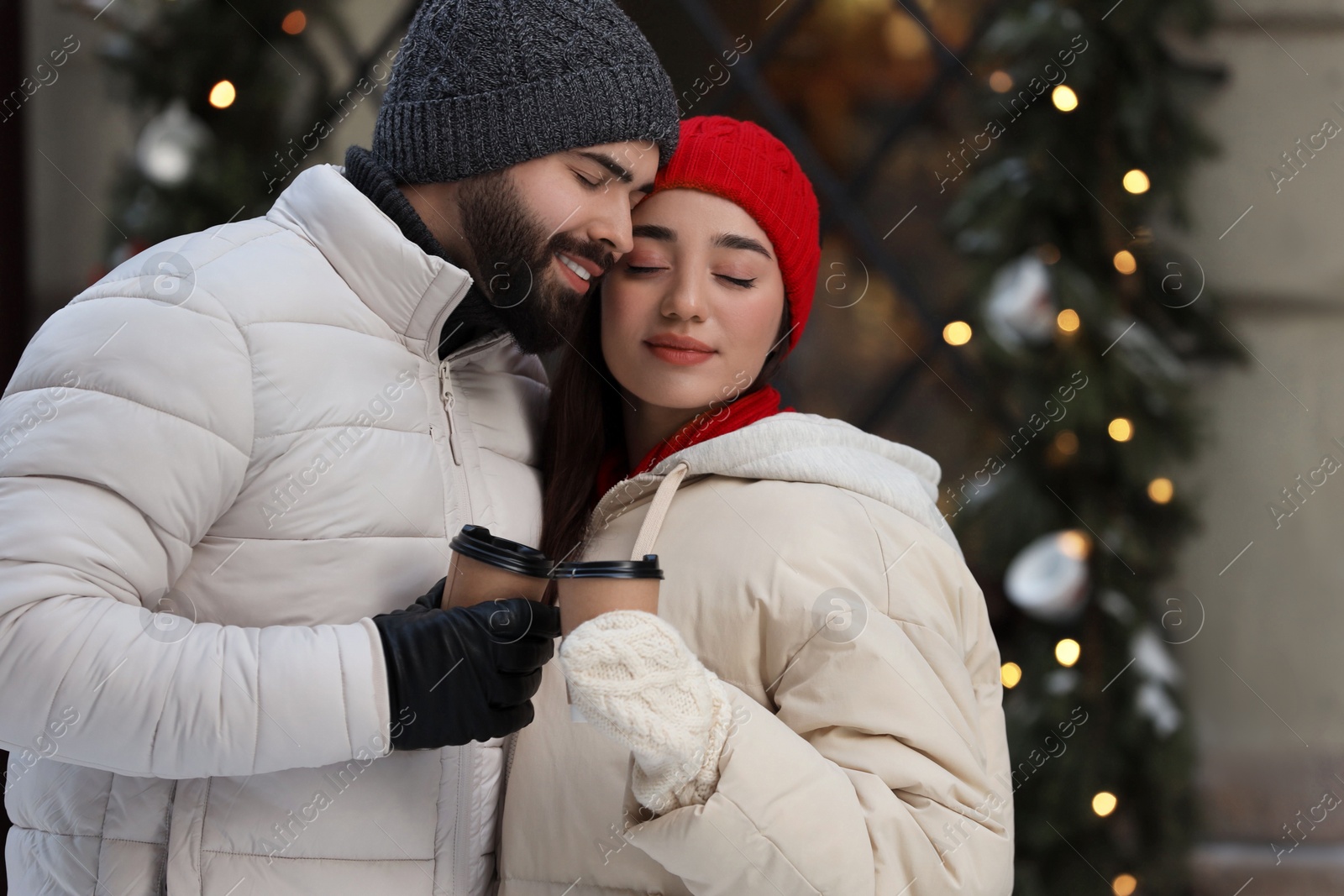 Photo of Lovely couple with hot drinks spending time together outdoors