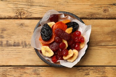 Mix of delicious dried fruits on wooden table, top view