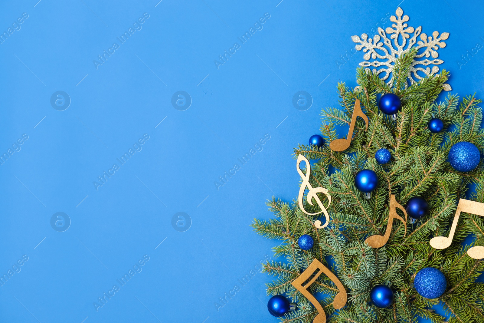 Photo of Flat lay composition with fir tree, Christmas decor and wooden music notes on color background. Space for text