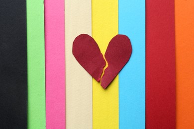 Halves of torn paper heart on colorful background, top view. Breakup concept