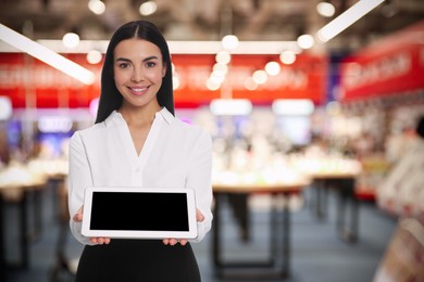 Image of Portrait of hostess wearing uniform with tablet in shopping mall. Space for text
