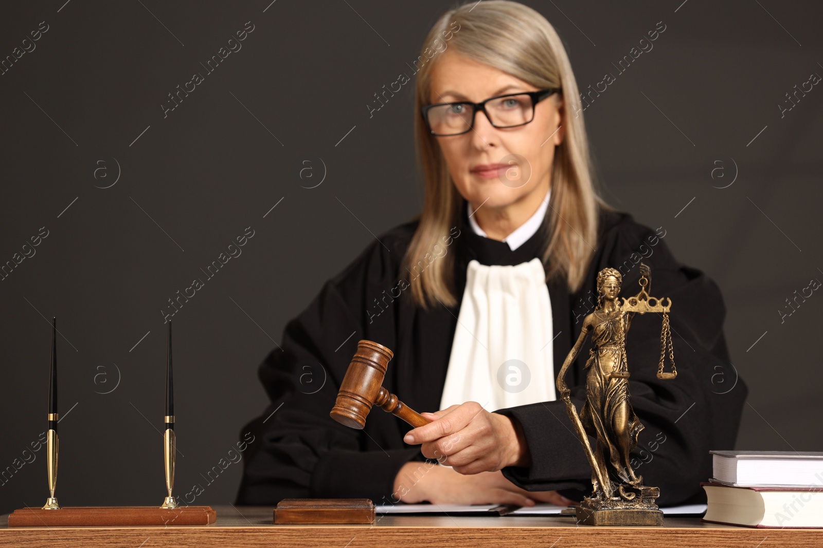 Photo of Judge striking mallet at wooden table indoors. Space for text