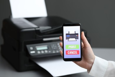 Man using printer management application on mobile phone indoors, closeup and space for text