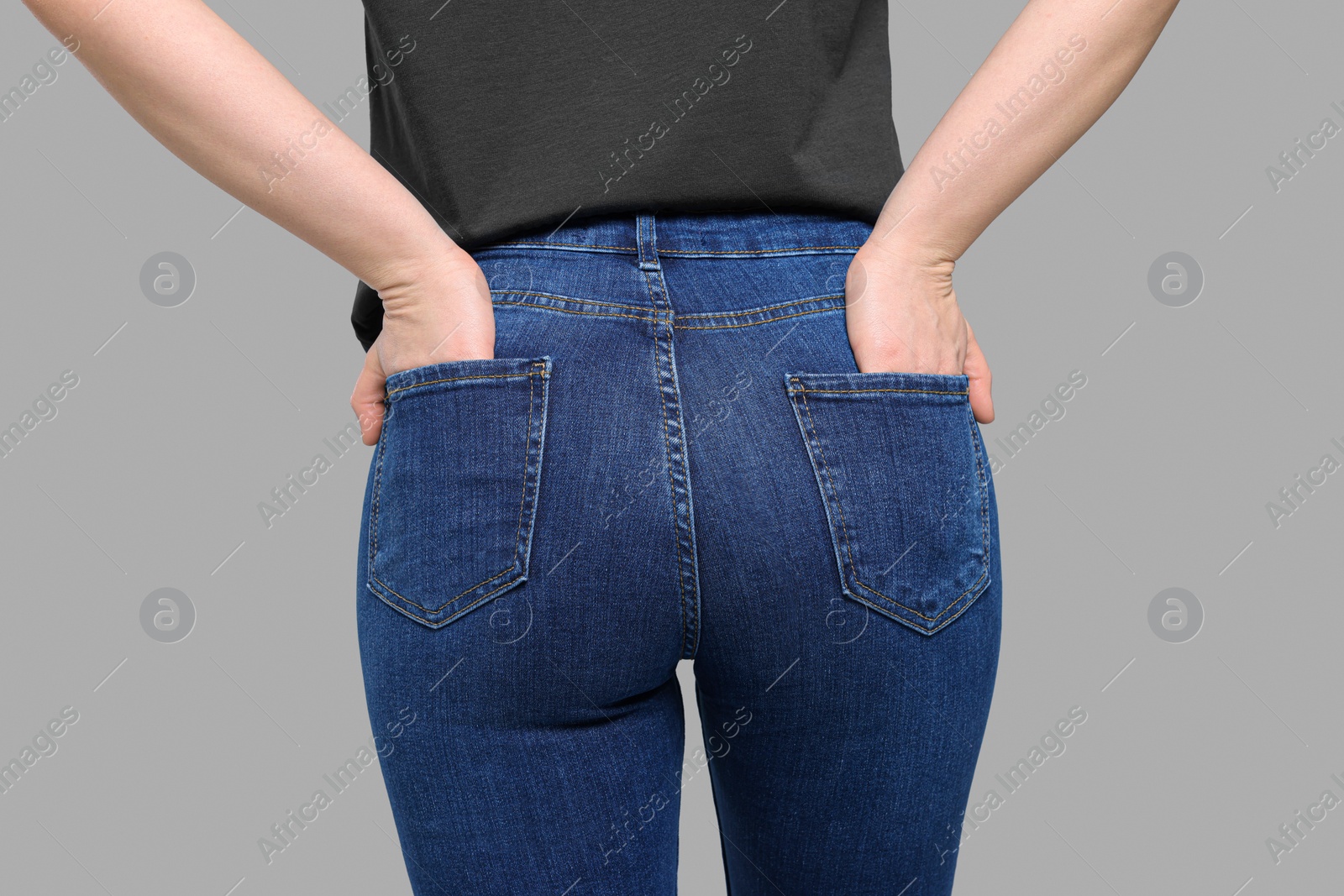 Photo of Woman in stylish jeans on grey background, closeup