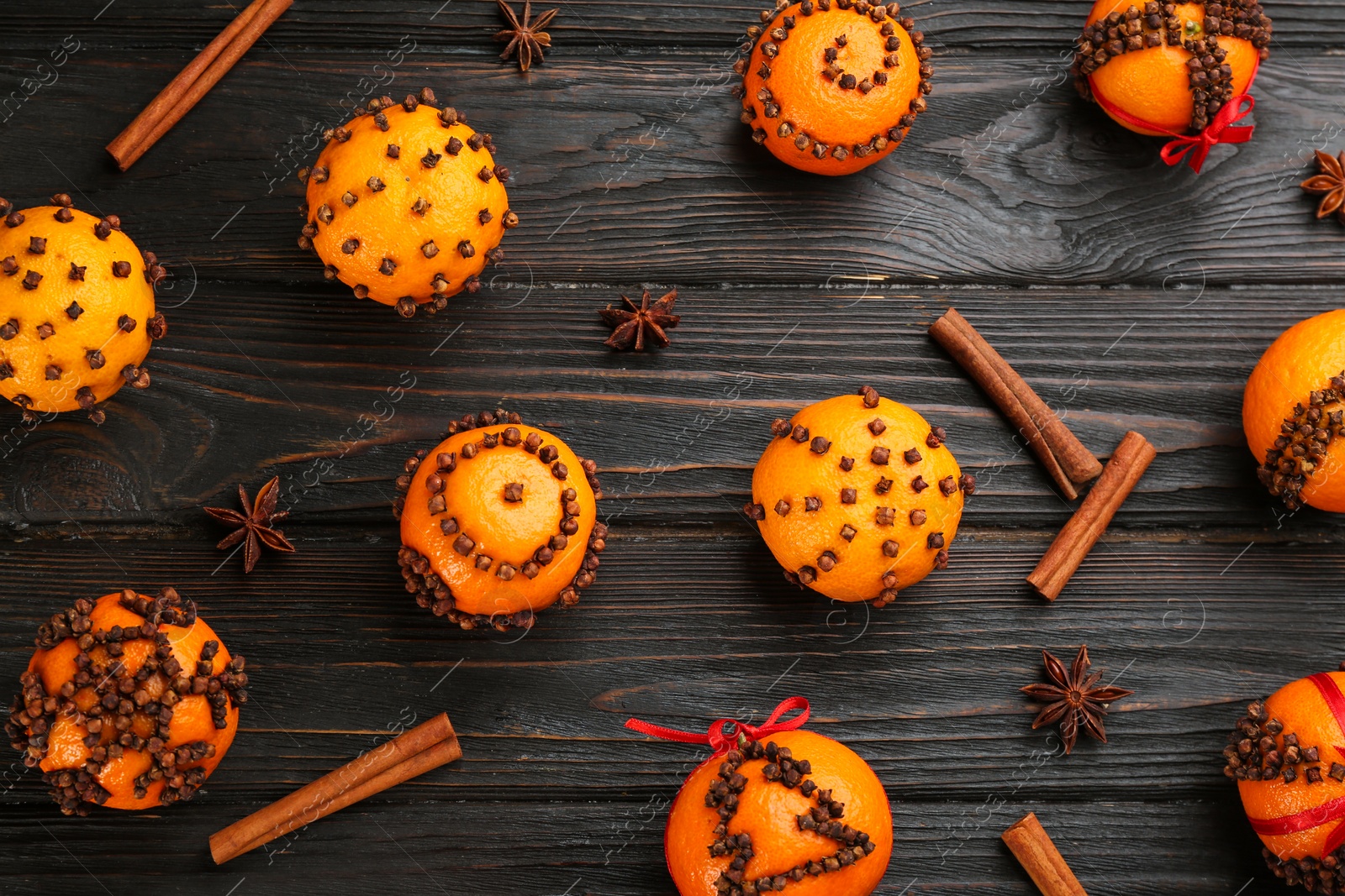 Photo of Flat lay composition with pomander balls made of fresh tangerines and cloves on wooden table