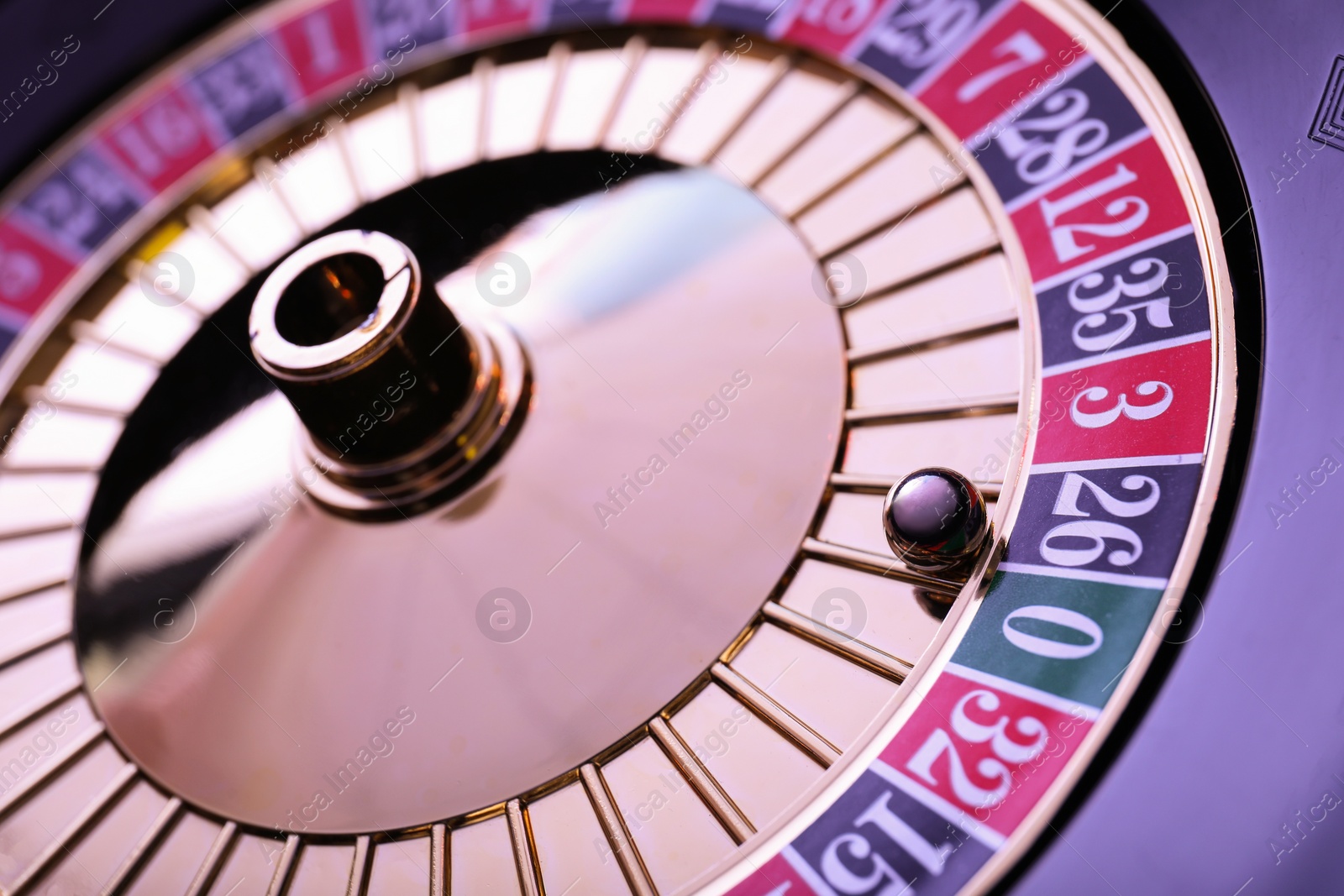 Photo of Roulette wheel with ball, closeup. Casino game