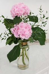 Beautiful pink hortensia flowers in vase on table indoors