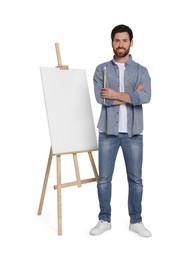 Happy man with brush near easel with canvas against white background. Creative hobby