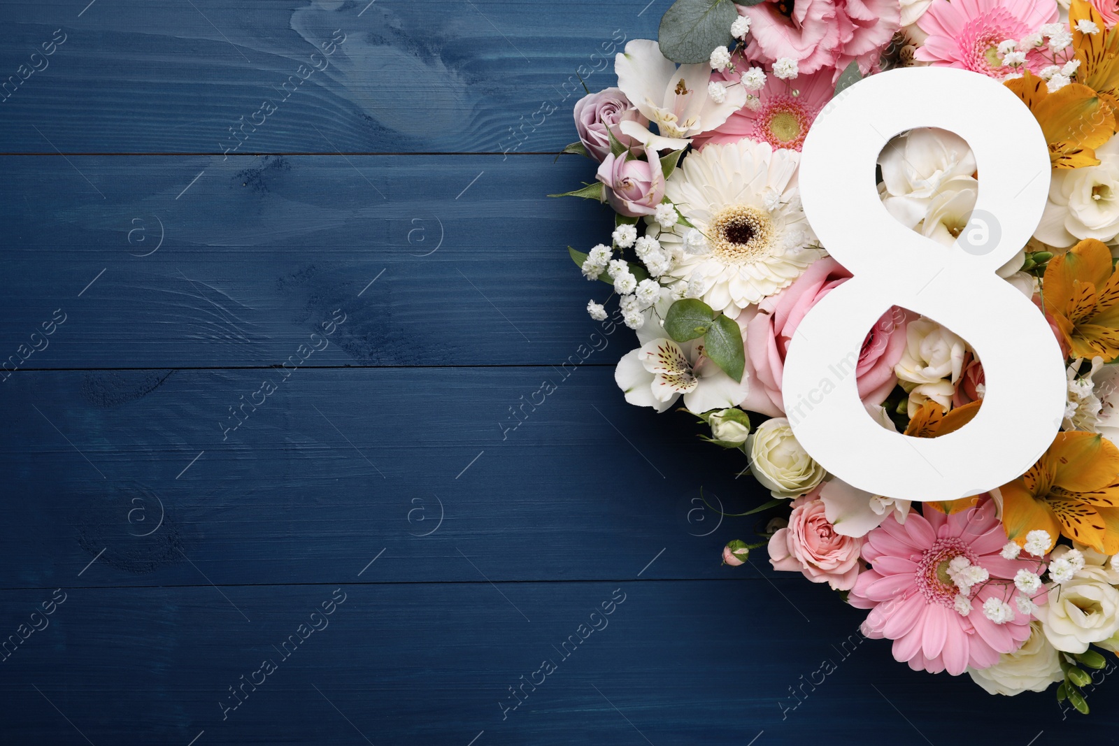 Photo of 8 March greeting card design with beautiful flowers on blue wooden table, flat lay and space for text. International Women's day