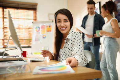 Photo of Portrait of happy female designer in office