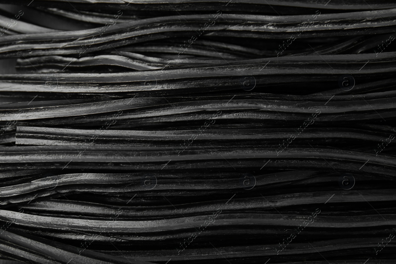 Photo of Tasty black liquorice candies as background, top view