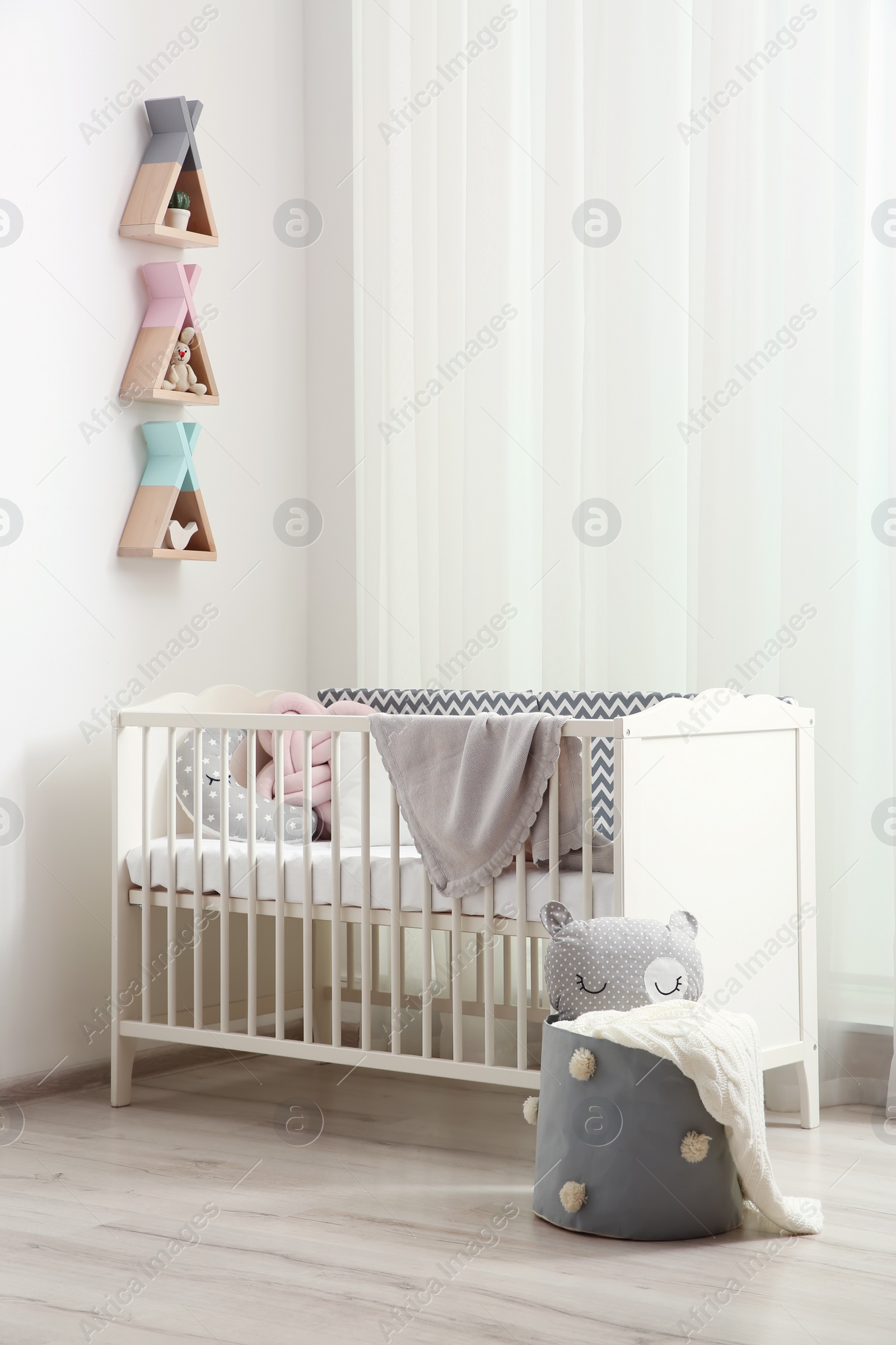 Photo of Wigwam shaped shelves over crib in baby room. Interior design