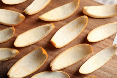 Photo of Many orange peels preparing for drying on wooden board, top view