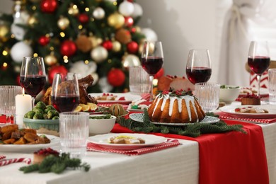 Festive dinner with delicious food and wine on table indoors. Christmas Eve celebration