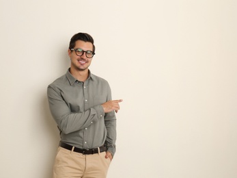 Photo of Young male teacher with glasses on beige background. Space for text