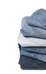 Stack of different folded jeans isolated on white