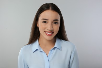 Portrait of beautiful young woman on light grey background