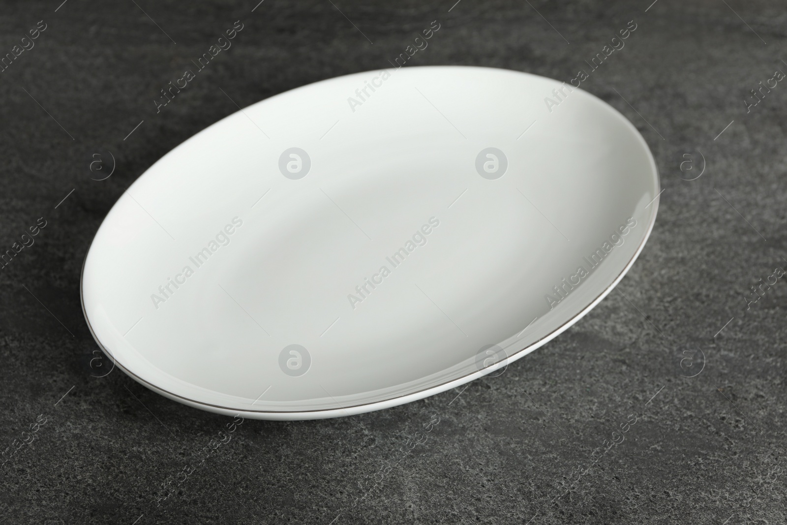 Photo of Empty clean ceramic plate on grey table