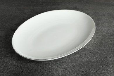 Empty clean ceramic plate on grey table