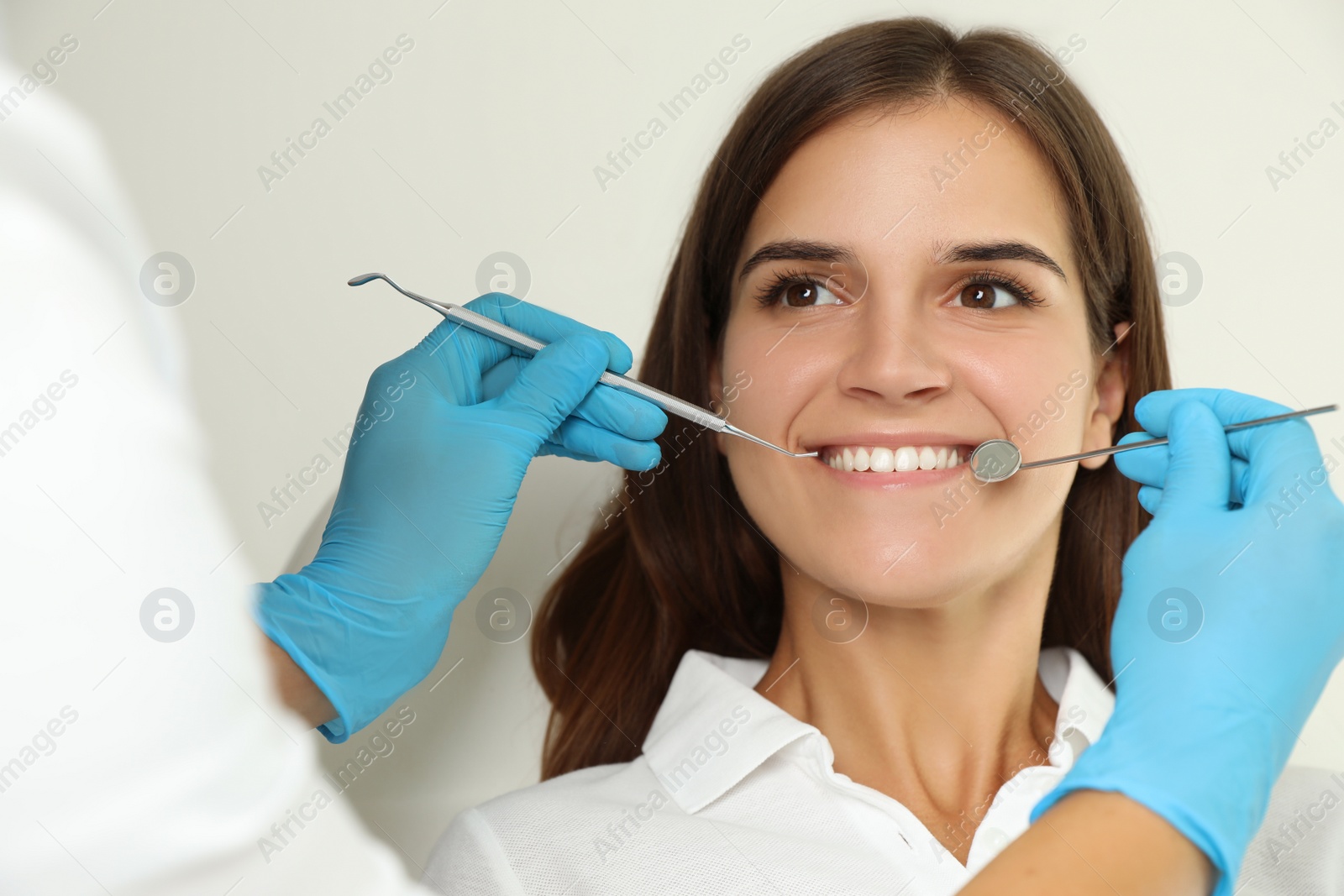 Photo of Dentist examining patient's teeth in modern clinic. Cosmetic dentistry