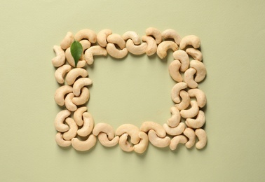 Photo of Frame made with tasty cashew nuts on color background, top view. Space for text