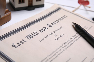 Last will and testament with pen on white table, closeup