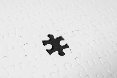 Photo of Blank white puzzle with missing piece on black background