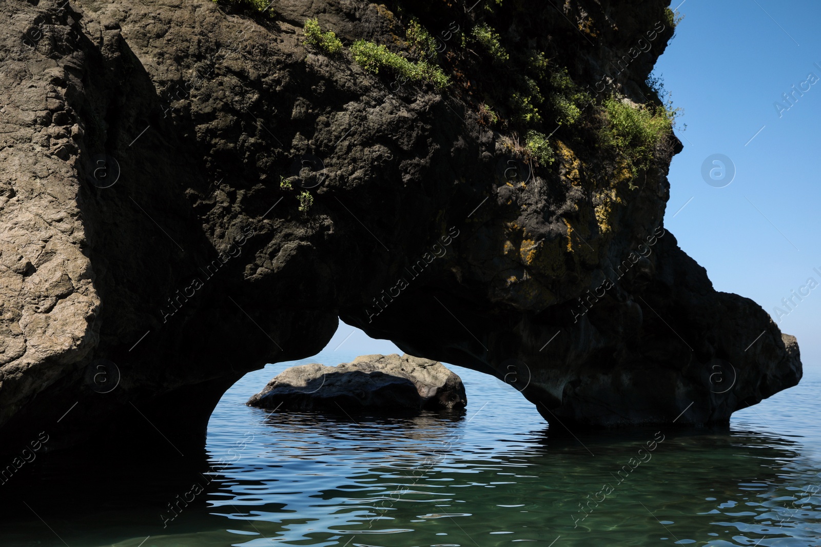 Photo of Picturesque view of natural stone arch above sea. Rock formation