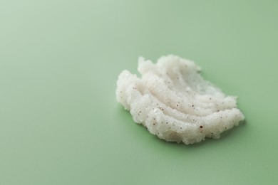 Photo of Sample of body scrub on green background, space for text