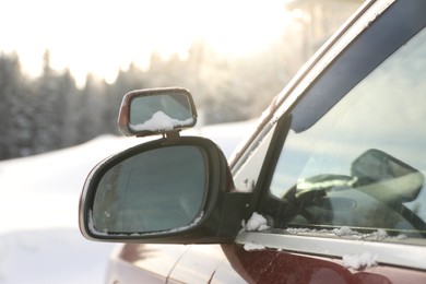 Photo of Side view mirror of car on snowy winter day, closeup