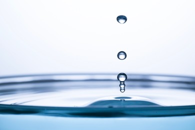 Photo of Splash of clear water with drops on light grey background, closeup